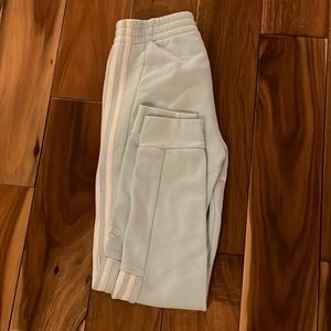 Baby blue sweatpants with three white stripes on the sides.